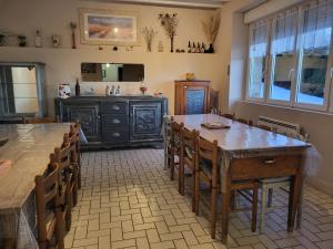 a dining room with wooden tables and chairs and a counter at Au doux refuge in Saint-Exupéry-les-Roches