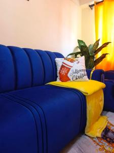 a blue couch with pillows on a yellow blanket at Atis Smart Stay in Kisumu