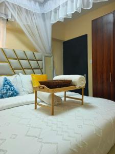 a bedroom with a bed with a bench on it at Atis Smart Stay in Kisumu
