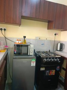 a kitchen with a microwave and a refrigerator at Atis Smart Stay in Kisumu