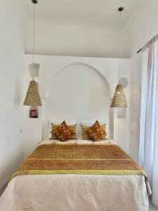 a bedroom with a large bed with two pendant lights at Dar Raphael in Essaouira