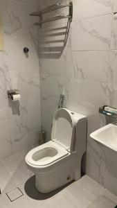 a bathroom with a white toilet and a sink at شقق مخدومه in Ash Shafa +5 photos