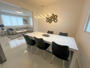 a dining room with a white table and chairs at Isabela Luxury Escape in Isabela
