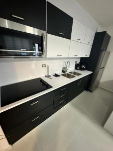 a kitchen with black and white cabinets and a sink at Isabela Luxury Escape in Isabela