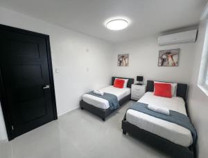 a bedroom with two beds and a black door at Isabela Luxury Escape in Isabela +37 photos