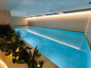 a swimming pool with blue water in a building at Adagio Quito Coliving Ecuador Residences in Quito