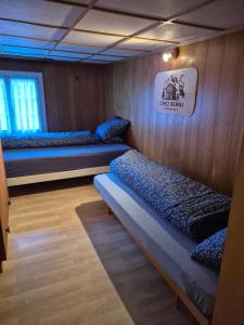 ein Zimmer mit drei Betten und einem Schild an der Wand in der Unterkunft Chez Berni in Andermatt