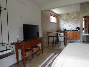 a bedroom with a bed and a television on a desk at Bangalo Bela Vista in Caparaó Velho