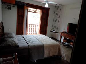a bedroom with a bed and a window and a desk at Bangalo Bela Vista in Caparaó Velho