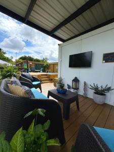 a patio with couches and a flat screen tv at Villa Morivivi Couples with pool in Tierras Nuevas Poniente