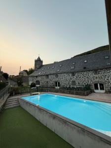 a large swimming pool in front of a building at Le Domaine Belinay in Paulhac