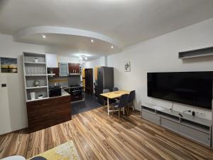 a living room with a table and a large flat screen tv at Central City Stay Šancová in Staré Mesto