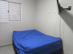 a blue bed in a room with a window at ótima casa em Itanhaém in Itanhaém +19 photos