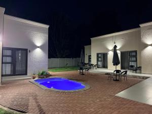 a patio with a blue swimming pool at night at Cathy & P Guesthouse in Hartbeespoort