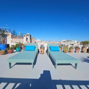 three blue benches sitting on top of a roof at Dar Raphael in Essaouira