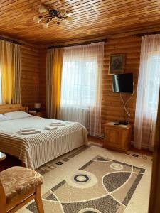 a bedroom with a bed and a tv in a room at Karpatska Mria in Yaremche +239 photos