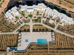 arial view of a large white building with a pool at White Cliff Villas Paros in Ambelas