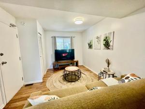 a living room with a couch and a flat screen tv at Charming Central Abbotsford Retreat, Cozy Suite in Abbotsford