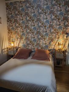 a bedroom with a bed with a floral wallpaper at Au doux refuge in Saint-Exupéry-les-Roches