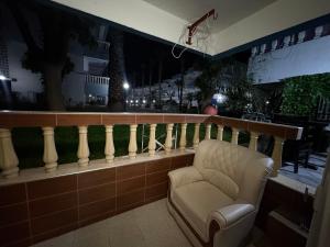 a chair sitting on top of a balcony at night at Palm Beach in Mansouria