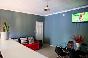 a living room with a couch and a tv at Luxe Residence Guest House in Kasane
