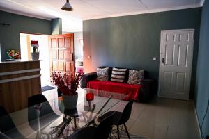 a living room with a couch and a glass table at Luxe Residence Guest House in Kasane