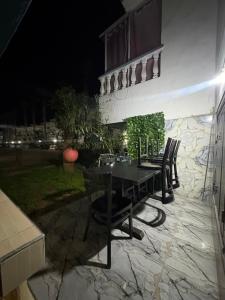 a table and chairs on a patio at night at Palm Beach in Mansouria