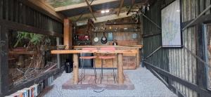 an outdoor bar with two stools in a building at The Clearing - Rustic Wagon by the Sea in Picton