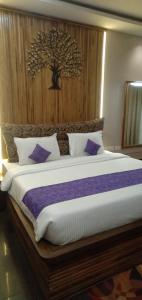 a bedroom with a large bed with a tree on the wall at Shashwat Resort in Gobindpur +36 photos