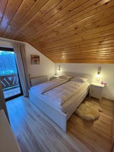 a bedroom with a large bed and a wooden ceiling at Casa de vacanta Mogosa in Baia-Sprie