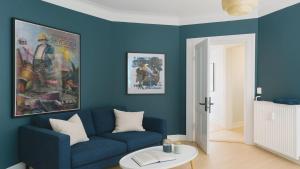 a living room with blue walls and a blue couch at Greenbrook Blue Suite in Aalborg
