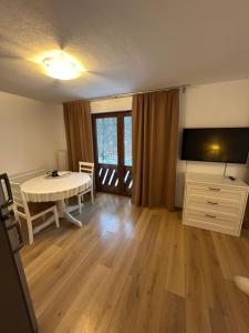 a living room with a table and a television at Casa de vacanta Mogosa in Baia-Sprie