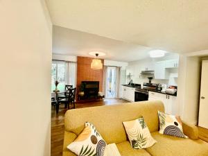 a living room with a couch and a kitchen at Charming Central Abbotsford Retreat, Cozy Suite in Abbotsford