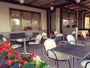 ペスキエーラ・デル・ガルダにあるHotel Bel Sitoのテーブルと椅子、花が飾られた空きレストランです。
