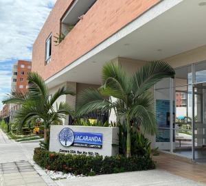 a sign in front of a building with palm trees at Casa ibague in Ibagué