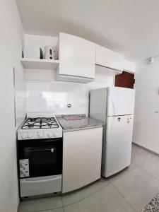 a kitchen with white cabinets and a stove and refrigerator at ADS DEPARTAMENToS 2 in La Plata