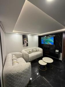 a living room with two couches and a flat screen tv at Casa ibague in Ibagué