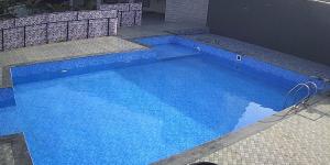a large blue swimming pool in a building at Shashwat Resort in Gobindpur