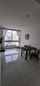 a room with a table and a bench and a window at ADS DEPARTAMENToS 2 in La Plata