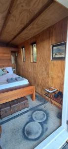 a bedroom with a bed and a table with at The Clearing - Rustic Wagon by the Sea in Picton