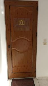 a wooden door with a house sign on it at Super central apartment with a view in Karpenisi