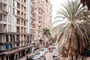 a street lined with tall buildings and a palm tree at Smouha Hotel in Alexandria