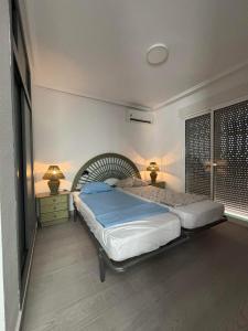 a bedroom with a bed and two lamps and a window at Rekkehus med uteplass in La Florida