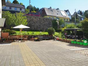 a patio with an umbrella and tables and chairs at Piroska Pension in Olbernhau