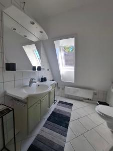 a white bathroom with two sinks and a window at Piroska Pension in Olbernhau +46 photos