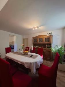 a dining room with a table and red chairs at Piroska Pension in Olbernhau
