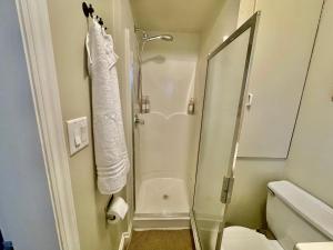 a bathroom with a shower with a glass door at Charming Central Abbotsford Retreat, Cozy Suite in Abbotsford +36 photos