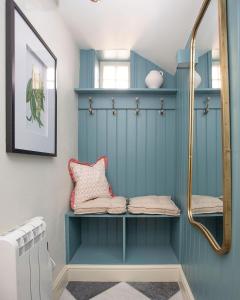 a bathroom with blue walls and a shelf at Luxurious Town Centre Apartments in Cirencester