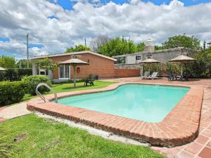 a swimming pool with a brick pathway around it at La Margarita Aparts - Solo 2 Pax in Mina Clavero