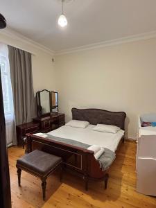 a bedroom with a bed with a mirror and a stool at RedRose guest house Dilijan in Dilijan +34 photos